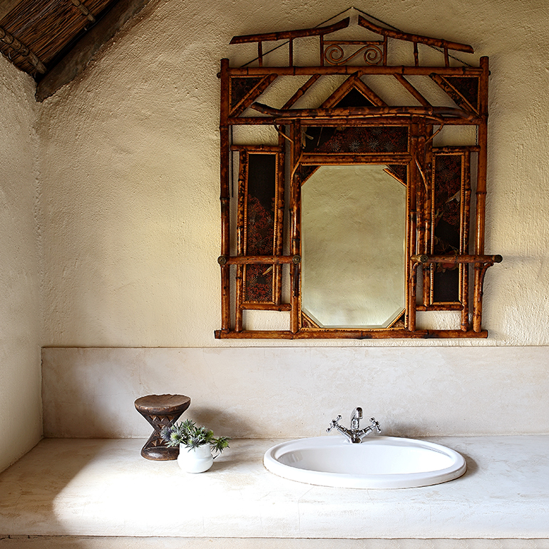A typical Elephant House en-suite bathroom with a handcrafted mirror above the basin.