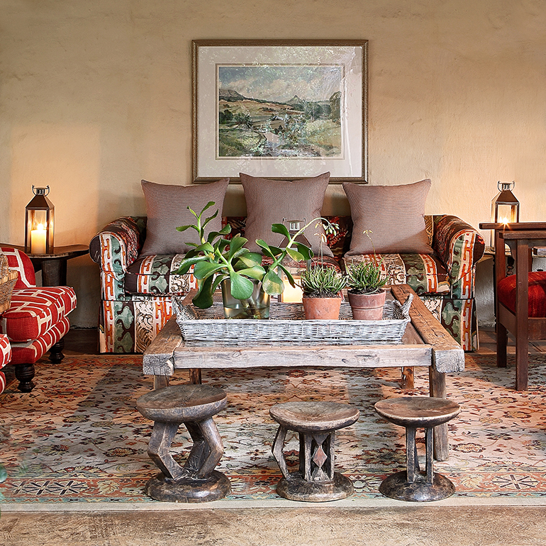 Deep open verandah with sofas, rugs and African artifacts, photo by Elsa Young.